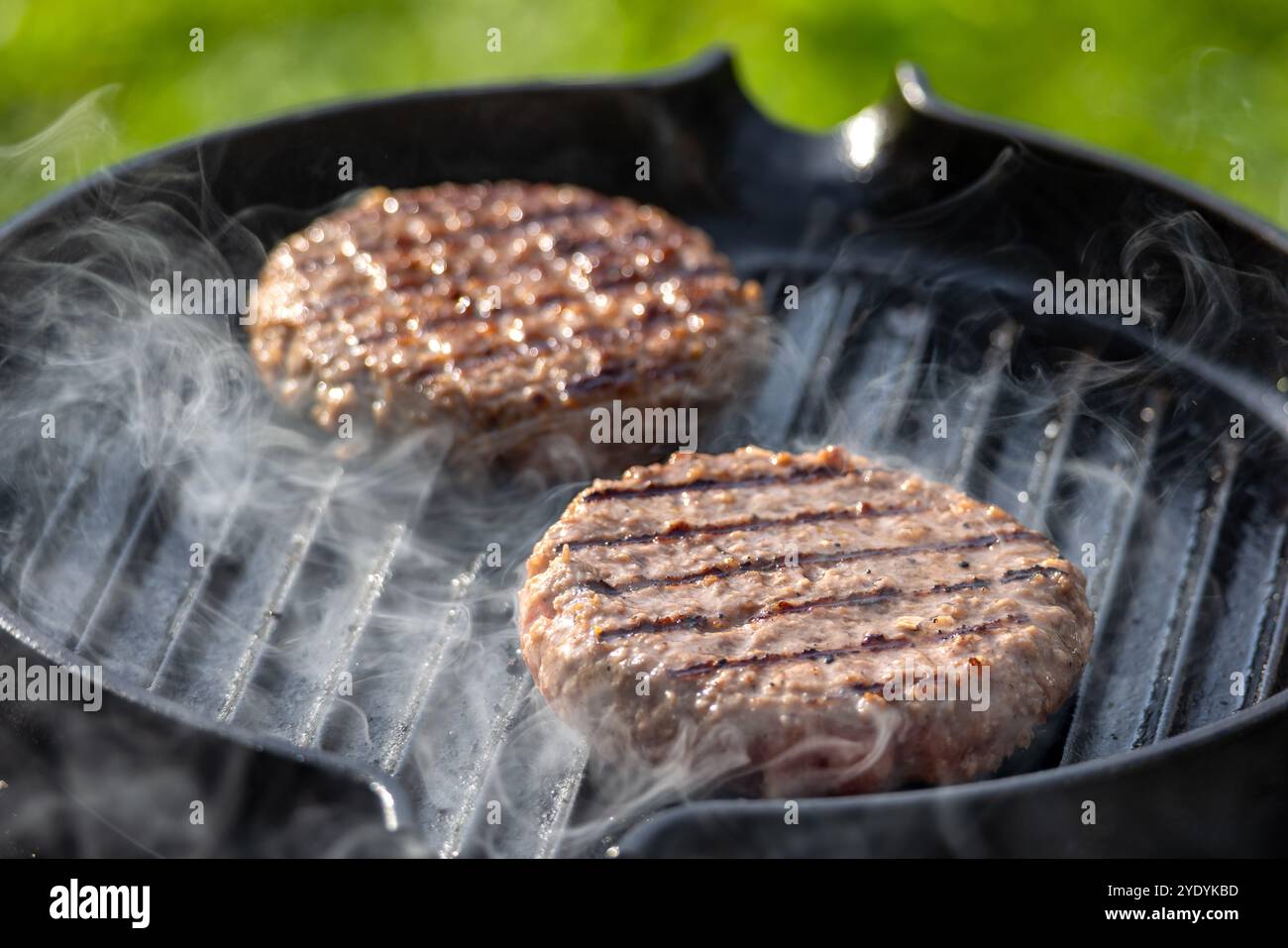 Frisches Burgerfleisch auf Grillpfanne Stockfoto