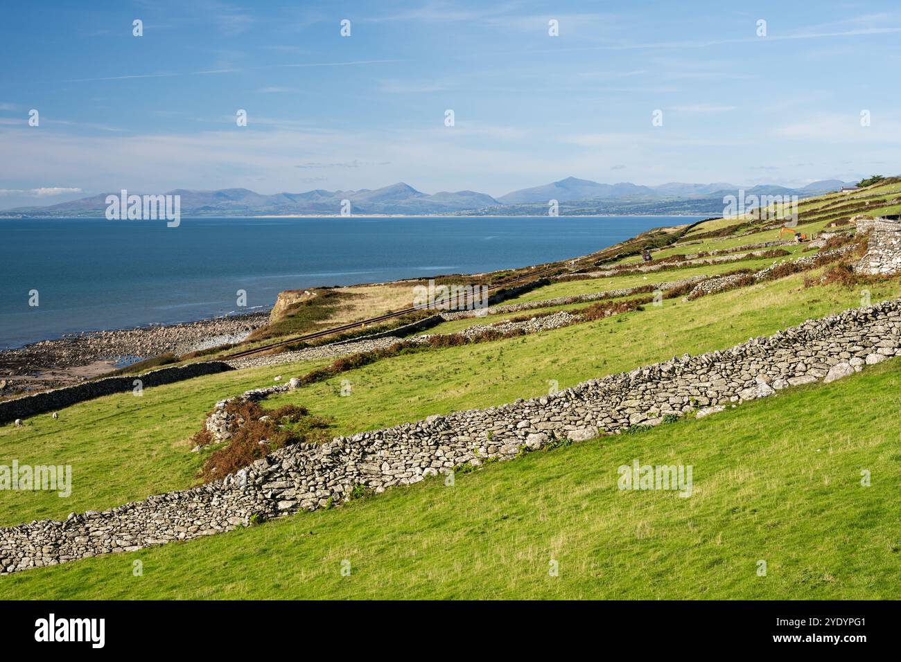 Die Berge von Snowdonia erheben sich in der Ferne über die Tremadog Bay aus Sicht von Llangelynin an der Küste von Wales. Stockfoto