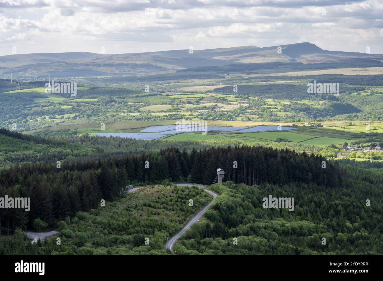 Wälder, Windparks und Solarpaneele am Ende des Vale of Neath Valley, mit dem Black Mountain Gebiet des Brecon Beacons National Park dahinter. Stockfoto