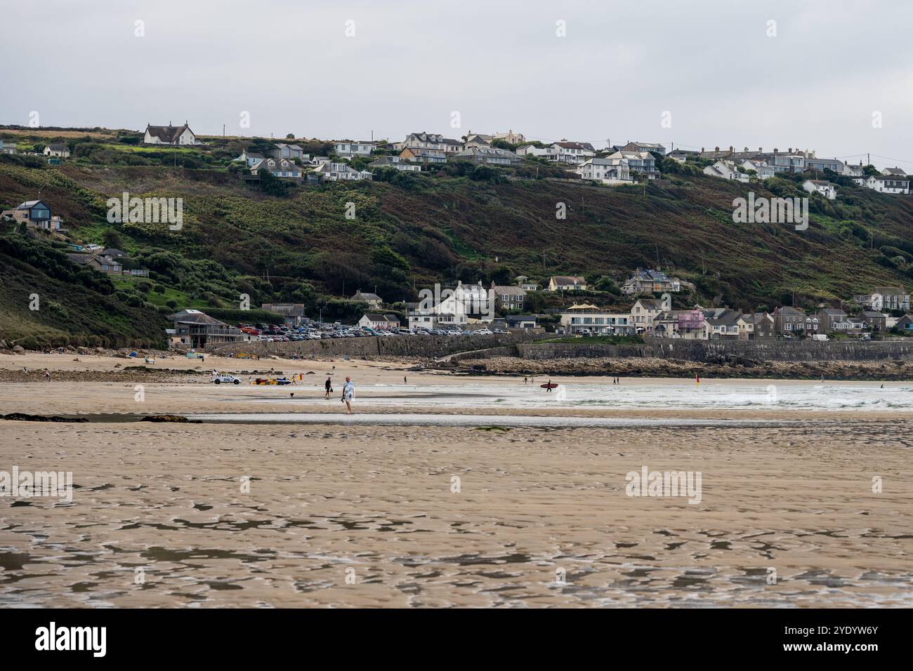 Surfer und Schwimmer am Strand von Sennen Cove im Westen von Cornwall, England. Stockfoto