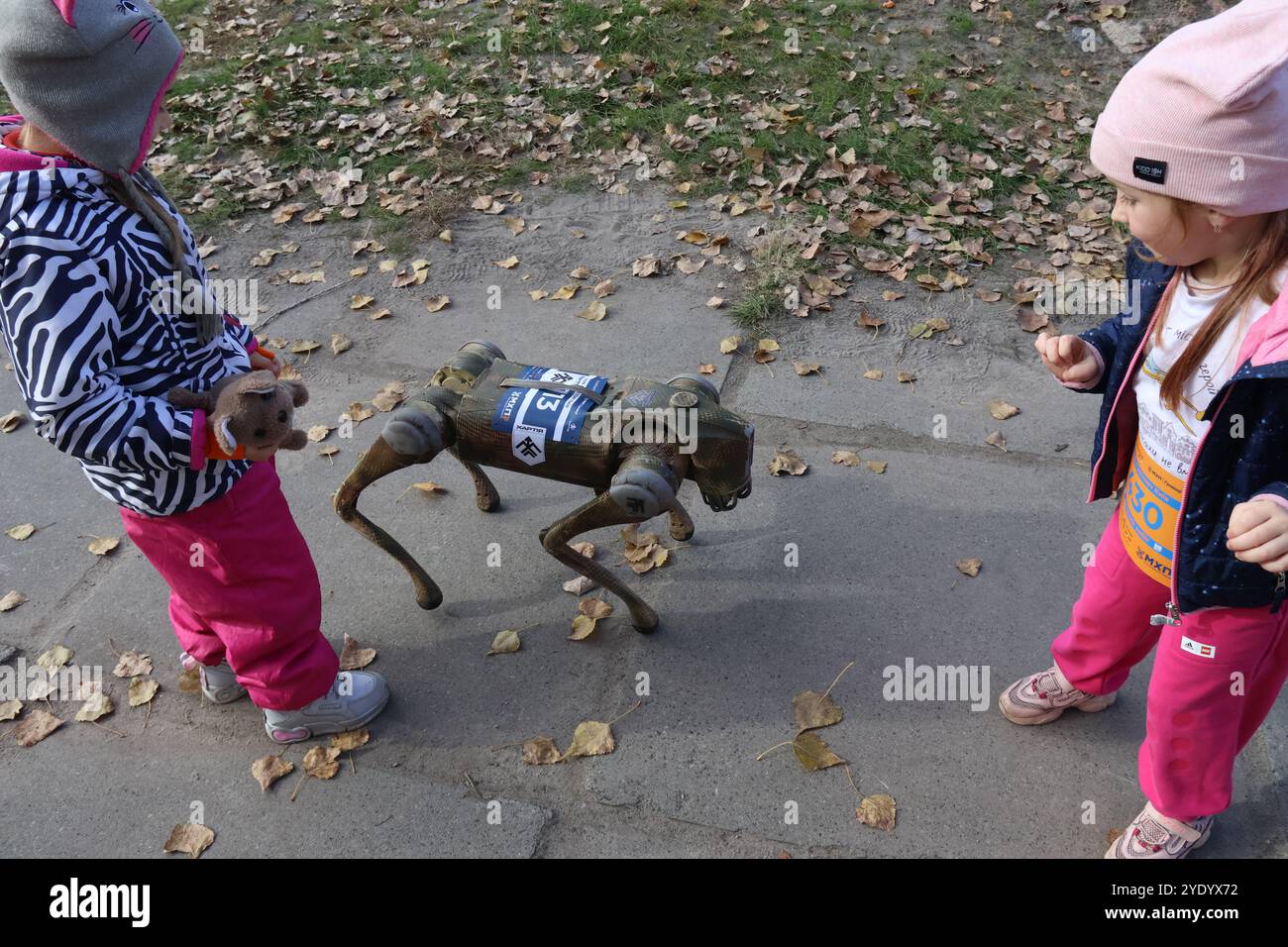 KIEW, UKRAINE - 27. OKTOBER 2024 - Kinder interagieren mit einem Roboterhund einer Aufklärungseinheit der Khartiia Brigade, die von Kampfeinsätzen in Kharkiw-Richtung während des Run4Victory-Wohltätigkeitslaufs zur Unterstützung der 13. Khartiia-Brigade der ukrainischen Nationalgarde auf der Insel Truchaniv, Kiew, Hauptstadt der Ukraine, zurückgekehrt ist. Mehr als 100 Soldaten schlossen sich während des Rennens Zivilisten an. Stockfoto