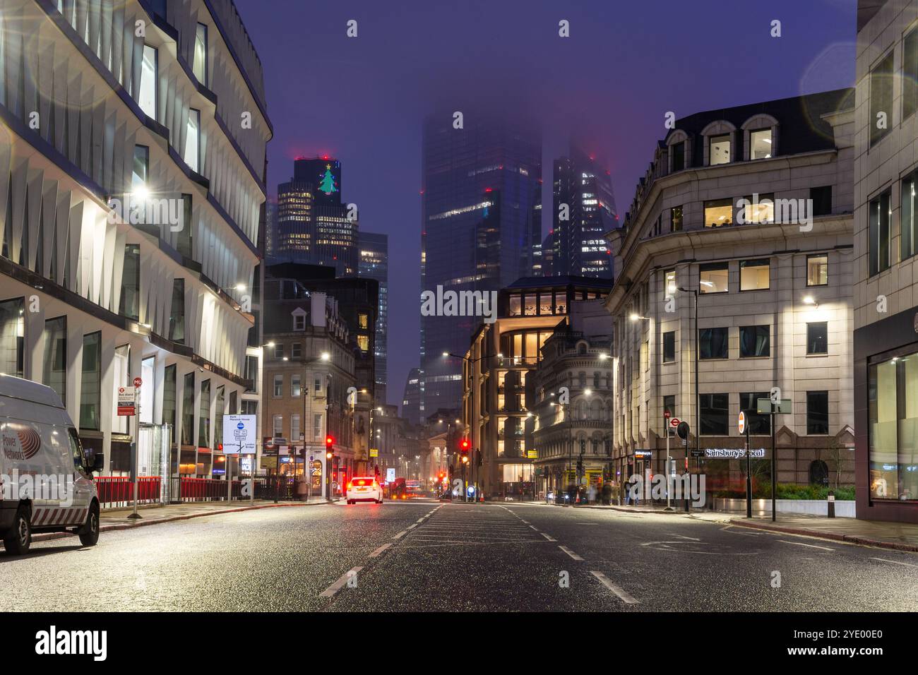 Wolkenkratzer des Geschäftsviertels der City of London erheben sich in einer Winternacht über der Queen Victoria Street. Stockfoto