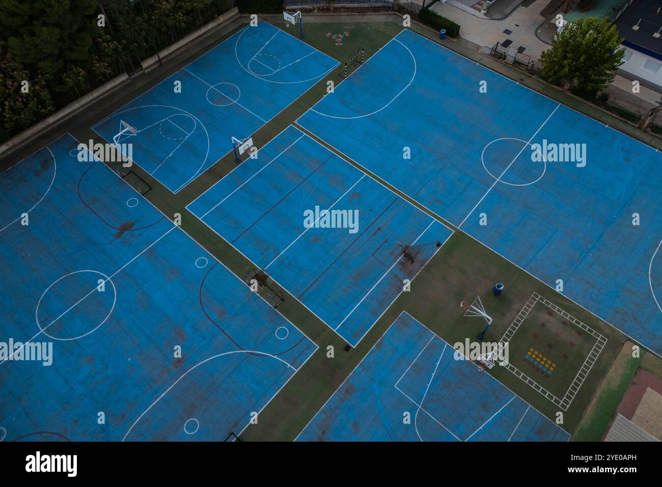 Blick aus der Vogelperspektive auf blaue Basketball- und Sportplätze auf dem Schulspielplatz Stockfoto