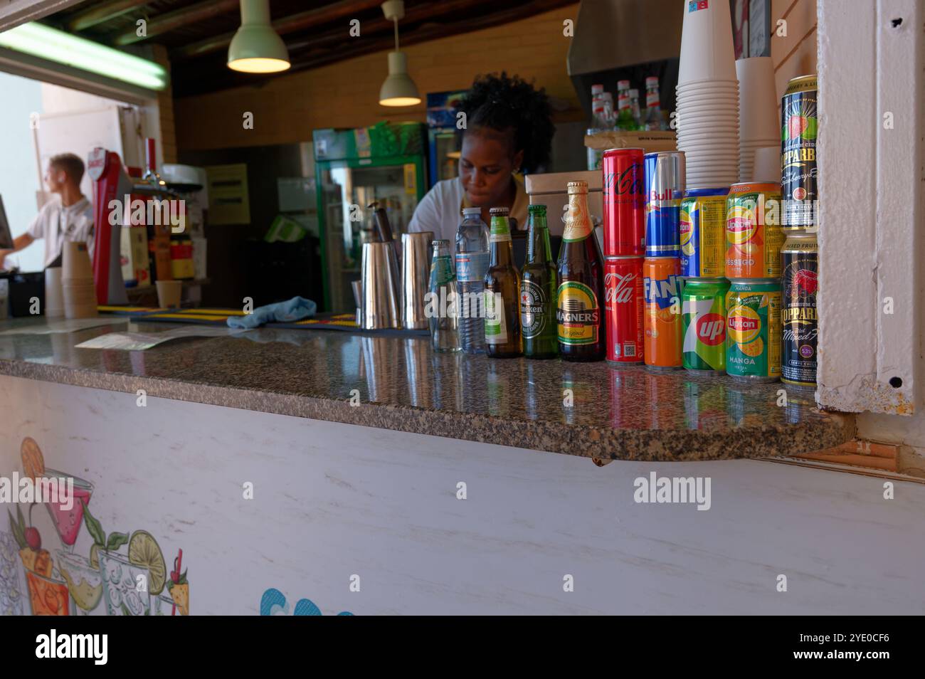 Farbenfrohe Präsentation von Dosengetränken und Flaschen in einer lokalen Café-Bar in Albufeira. Stockfoto