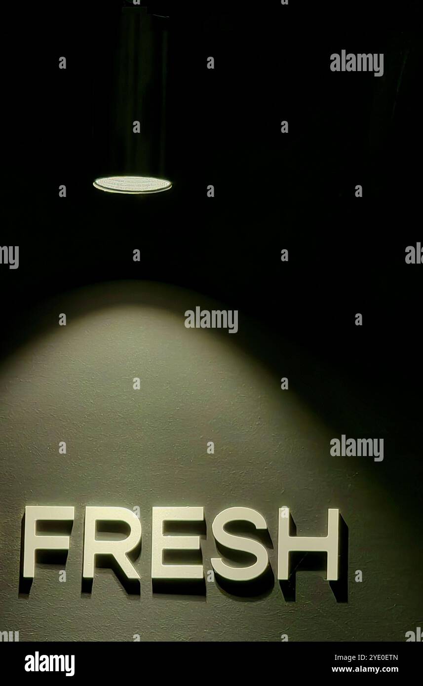 „Fresh“ in Lights: Beleuchtetes Wort auf der Cafeteria-Wand mit einem filmischen Leuchten Stockfoto