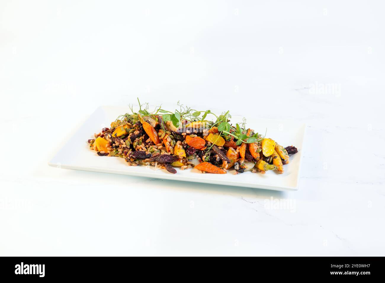 Große Platte mit Quinoa-Salat mit gerösteten Karotten, Datteln und Mikrogemüse Stockfoto