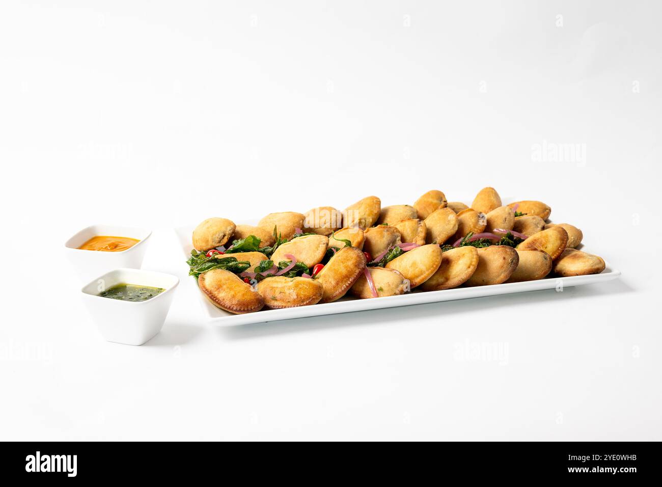 Eine Platte Empanadas mit zwei verschiedenen Saucen zum Tauchen Stockfoto