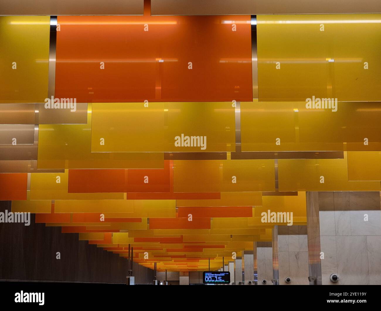 Innenraum der U-Bahn-Station Nowatorskaja an der Bolschaja Koltsewaya-Linie (BKL) der Moskauer U-Bahn, mit orangefarbenen und gelben Tafeln von der Decke Stockfoto