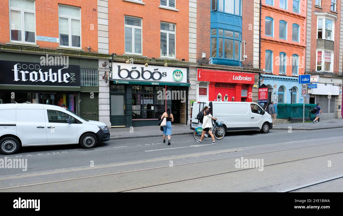 Middle Abbey St in Dublin, Irland Straßenszene; lokale Unternehmen; Bobos Gourmet Irish Burgers, Ladbrokes, Good Trouble Ink Tattoo Shop, Fußgänger. Stockfoto