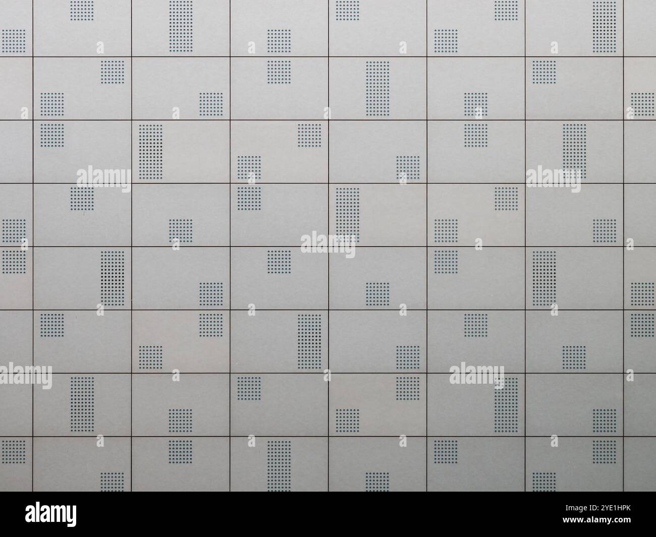 Wandmuster aus nächster Nähe bauen. Graue Fliesen mit perforiertem Design. Abstrakter Hintergrund mit dem architektonischen Merkmal der Fassade. Stockfoto