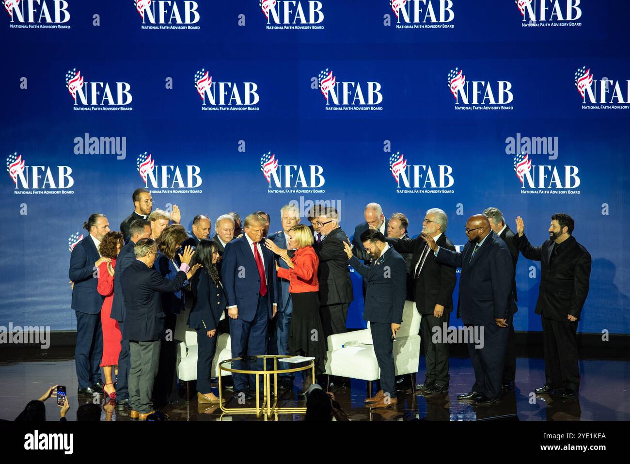 Der ehemalige US-Präsident Donald J Trump, der 2024 für die Republikanische Partei nominierte Präsident der USA, wird von seiner Pastorin Paula Michelle White-Cain und verschiedenen Geistlichen auf der Bühne begleitet, während er am Montag, den 28. Oktober 2024, auf dem National Faith Advisory Summit bei der Anbetung mit Wundern Church in Marietta, Georgia, spricht. Kredit: Andi Reis/CNP/MediaPunch Stockfoto