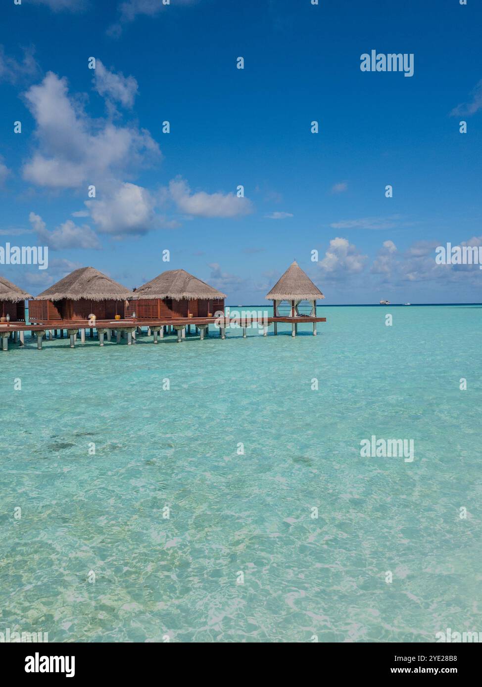 Entfliehen Sie dem Paradies! Kristallklares, türkisfarbenes Wasser, Bungalows über dem Wasser und endloser blauer Himmel machen diesen tropischen Hafen zum ultimativen Kurzurlaub - Smartphone-aufgenommenes Stockfoto