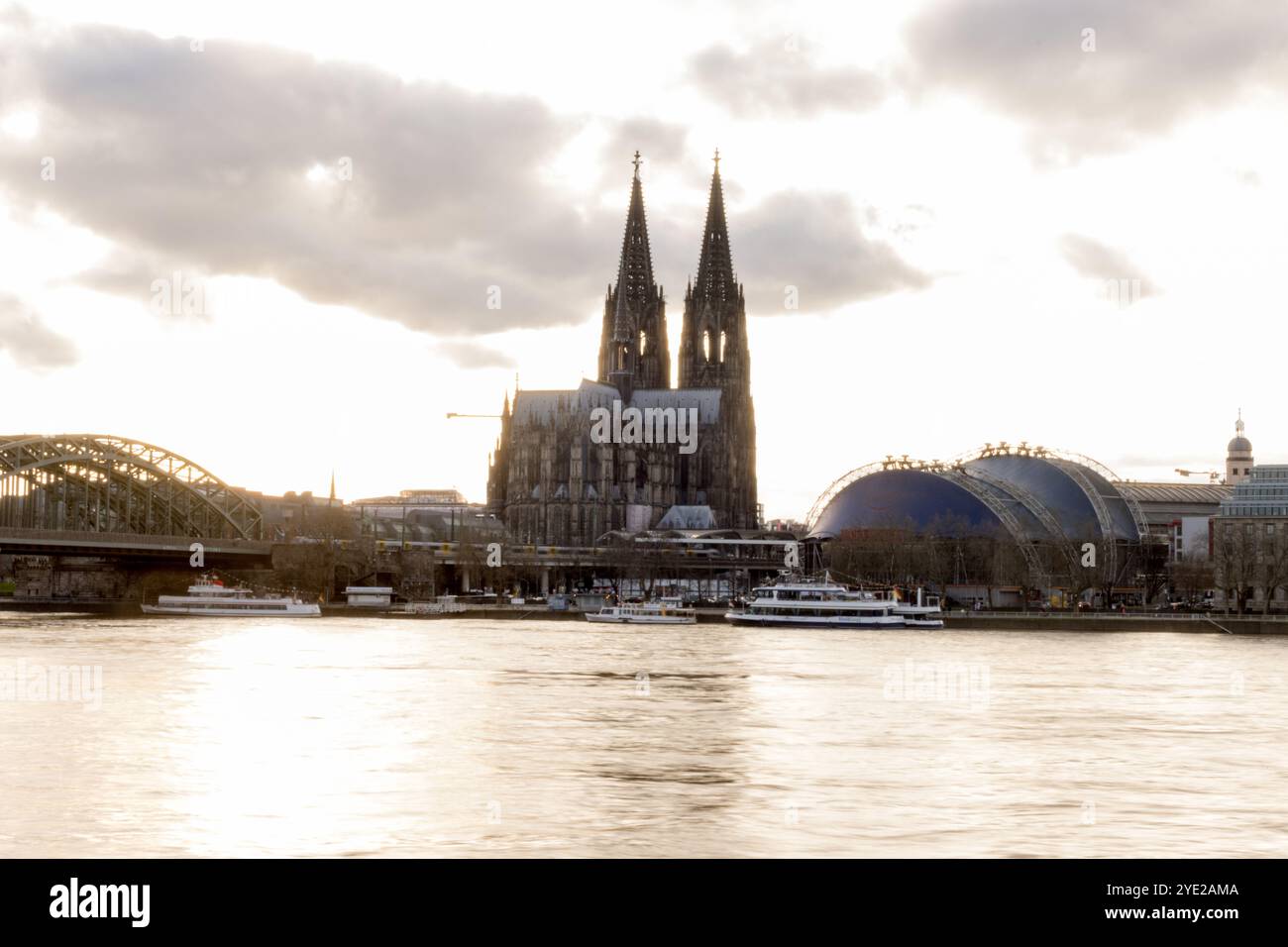 Der berühmte Kölner Dom und die Hohenzollernbrücke stehen majestätisch am Rhein in Köln und sorgen für einen malerischen Abend. Stockfoto