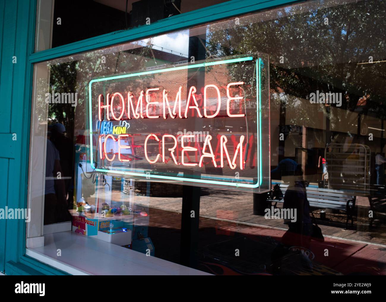 Neon Shop Schild im Ladenfenster „hausgemachte Eiscreme“ in Old Town, Kissimmee, Florida im Oktober 2024 mit einer Reflexion der Käufer, die vorbeigingen. Stockfoto