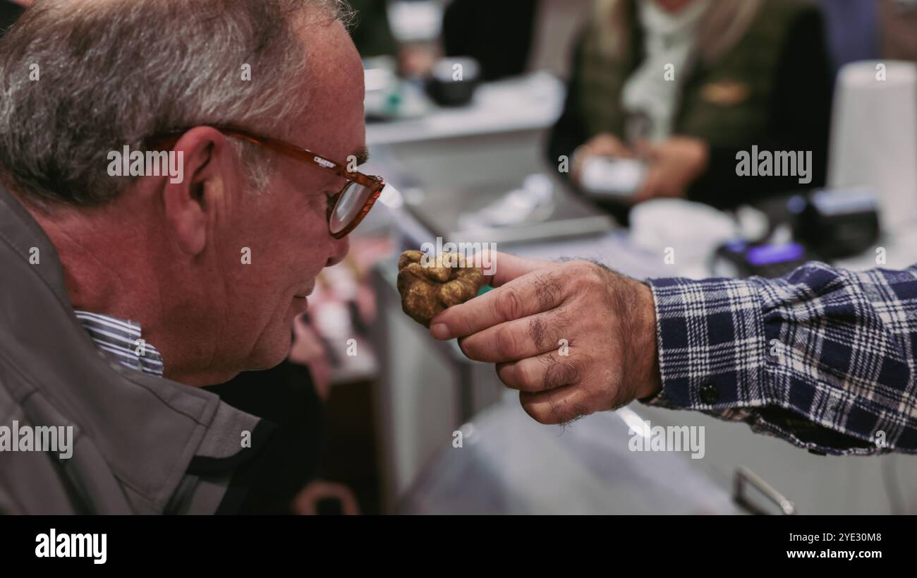 Beim Alba-Trüffelfestival riecht ein begeisterter Besucher einen frisch gefundenen Trüffel, der die reiche kulinarische Tradition Italiens zeigt. Stockfoto