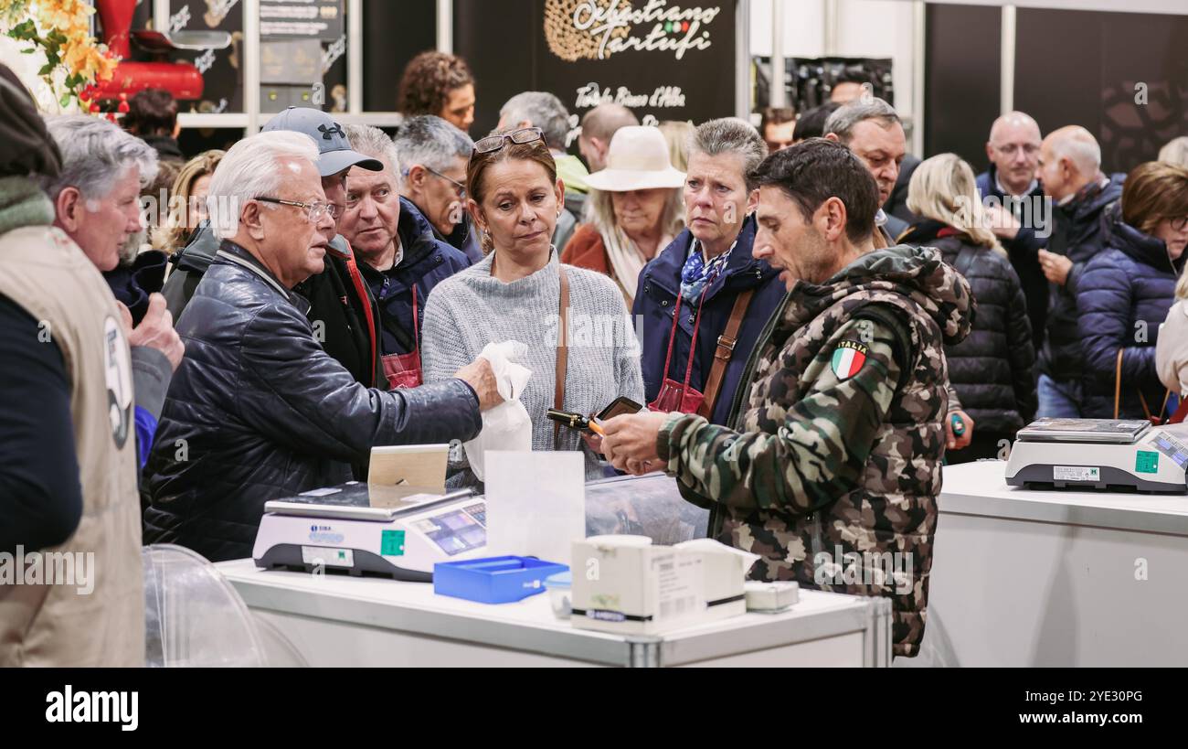 Begeisterte Teilnehmer interagieren mit Händlern beim Alba Truffle Festival in Italien und entdecken Gourmet-Trüffel und lokale Köstlichkeiten. Stockfoto