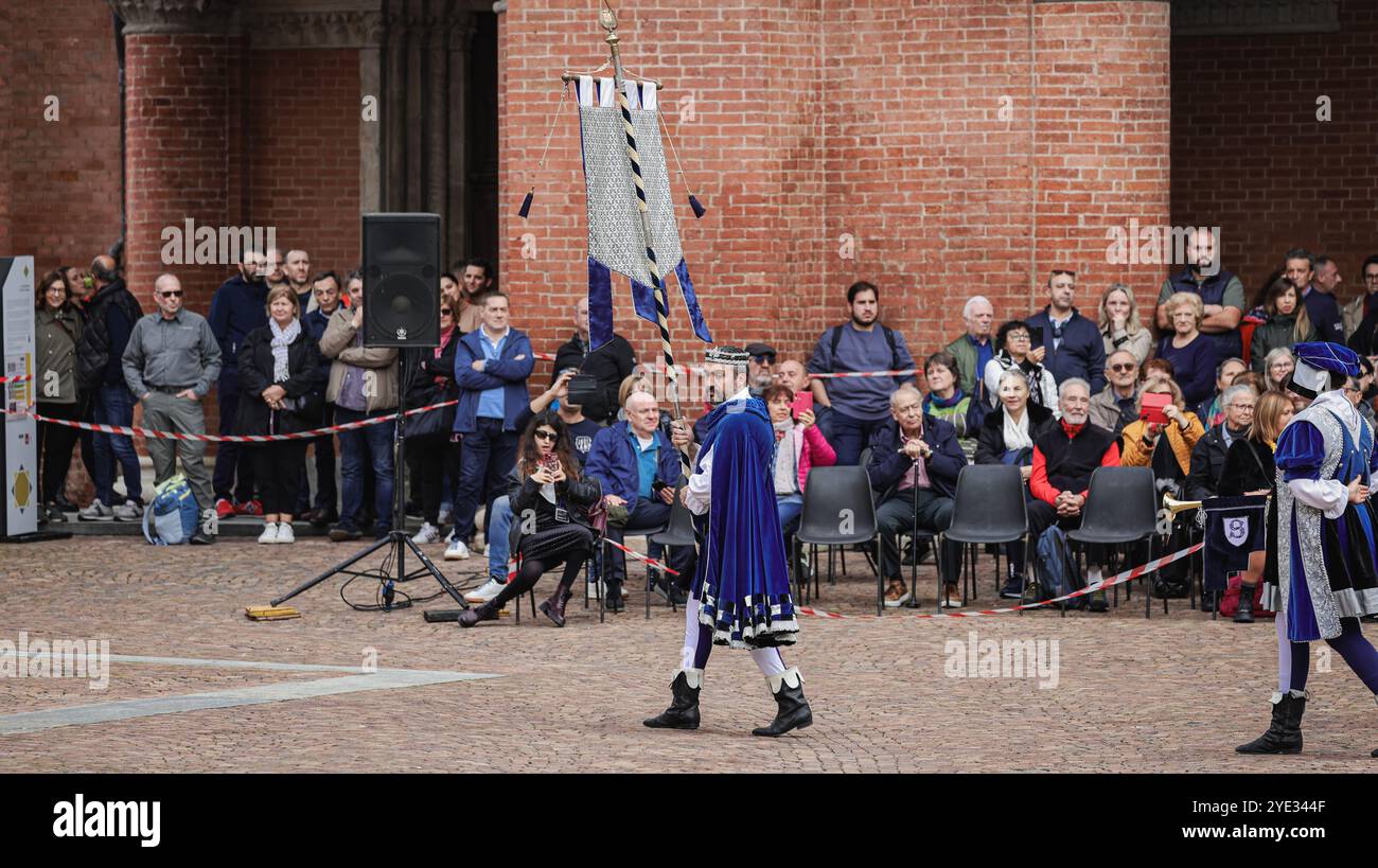 In Alba, Italien, findet eine farbenfrohe Parade statt, während die in historischen Kostümen gekleideten Teilnehmer unter den Massen von begeisterten Zuschauern spazieren gehen, die das C genießen Stockfoto