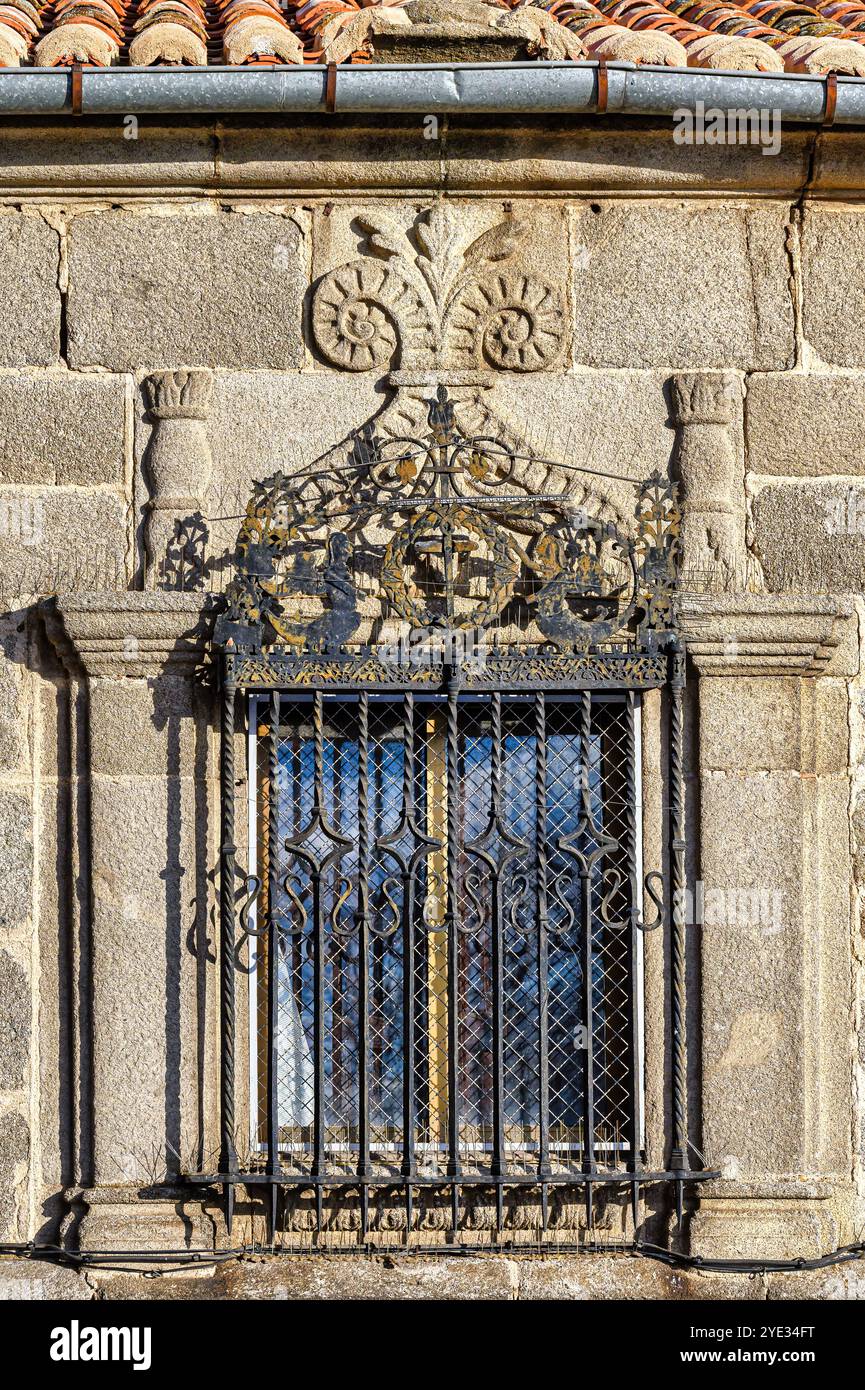 Avila, Spanien - 11. Februar 2023: Architektonisches Merkmal eines antiken Fensters an der Steinmauer eines mittelalterlichen Gebäudes. Stockfoto