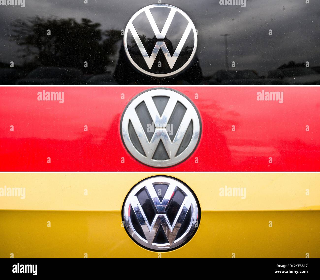 Wolfsburg, Deutschland. Oktober 2024. KOMBO – das VW-Logo auf einer schwarz-rot-goldenen Motorhaube im Stil der deutschen Flagge ist auf einem Mitarbeiterparkplatz im VW-Hauptwerk zu sehen. VW und der betriebsrat ringen seit Wochen um mögliche Betriebsschließungen und Entlassungen. Nach Angaben des betriebsrats liegen nun die ersten konkreten Pläne auf dem Tisch. Quelle: Julian Stratenschulte/dpa/Alamy Live News Stockfoto
