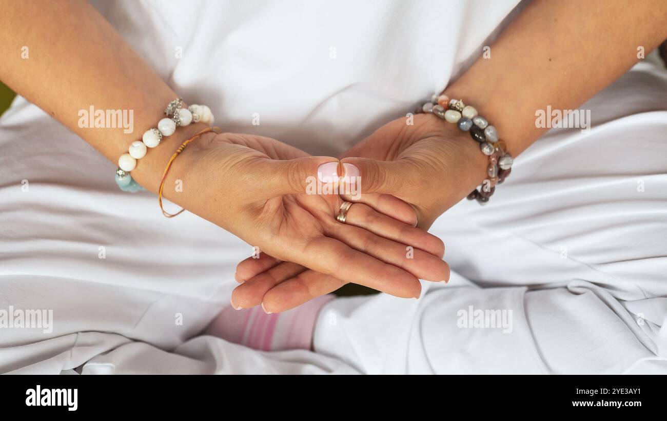 Frau übt Kundalini Yoga, Meditation sitzend in Lotusposition, Variation von Dhyana Mudra oder Samadhi Mudra Geste mit Händen Stockfoto