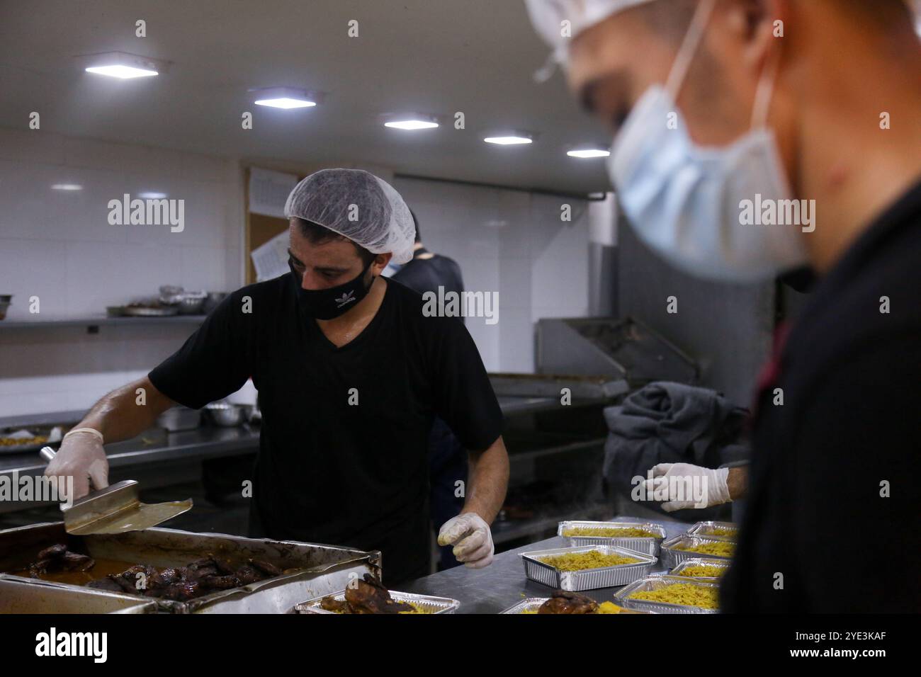 Gaza, Palästina. August 2020. Hunderte von Mahlzeiten werden zubereitet, um Menschen in den Quarantänezentren in Gaza-Stadt zu ernähren. In der vergangenen Woche wurden erstmals COVID-19-Fälle in der Gemeinschaft des dicht besiedelten Gazastreifens entdeckt, was tiefe Bedenken darüber aufwirft, dass sein überlastetes und unzureichendes Gesundheitssystem bald überfordert werden könnte. Die Fälle des Coronavirus haben in der belagerten Küstenenklave in der Tat stetig zugenommen, da die Gesundheitskrise durch die aktuellen Spannungen mit Israel verschärft wurde, die verhindern, dass Treibstoff in Gaza eindringt und schwere Stromknappheit verursacht Stockfoto