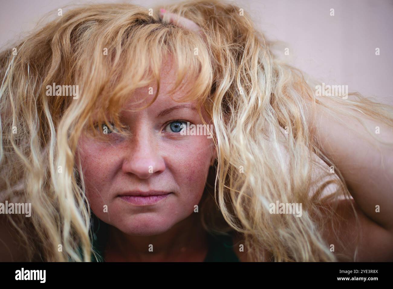 Nahporträt einer Frau mit strohfarbenen Haaren und durchdringendem Blick, der Tiefe und Nachdenklichkeit vermittelt. Stockfoto
