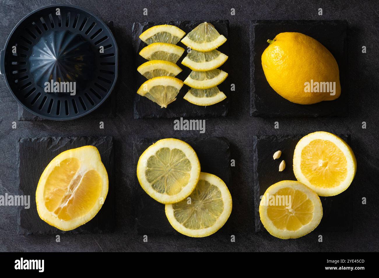 Elegantes Hintergrunddesign aus Zitronen und Zitronenscheiben mit Quetschpresse und Messer auf dunkler oder schwarzer Zement- oder Steinoberfläche.Draufsicht mit Kopierraum. Stockfoto
