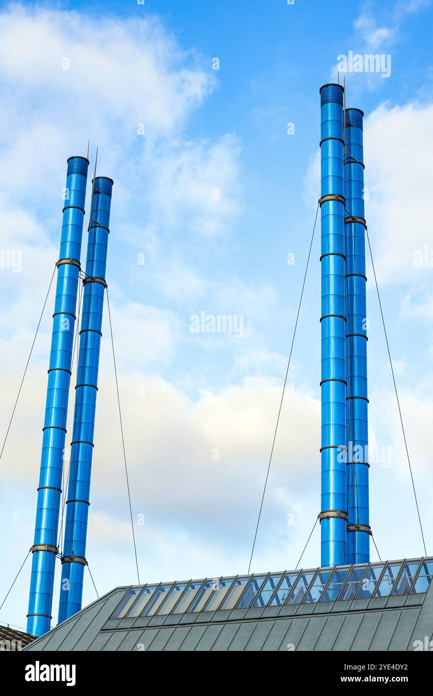 Blaue Rohre des städtischen Kesselhauses. Heizraum mit rauchlosen Rohren. Hohe Schornsteine auf dem Dach. Vertikales Foto. Stockfoto