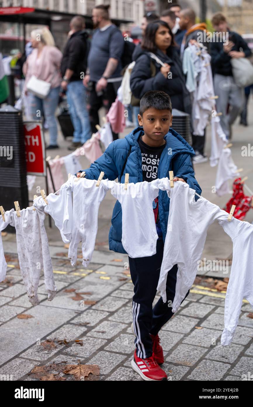 London, Großbritannien. Oktober 2024. Pro Palestine marschiert in Westminster, um gegen die mutmaßliche Ermordung von Kindern in Gaza zu protestieren. Die Demonstranten hatten Seile mit Babykleidung. Quelle: Ian Davidson/Alamy Live News Stockfoto