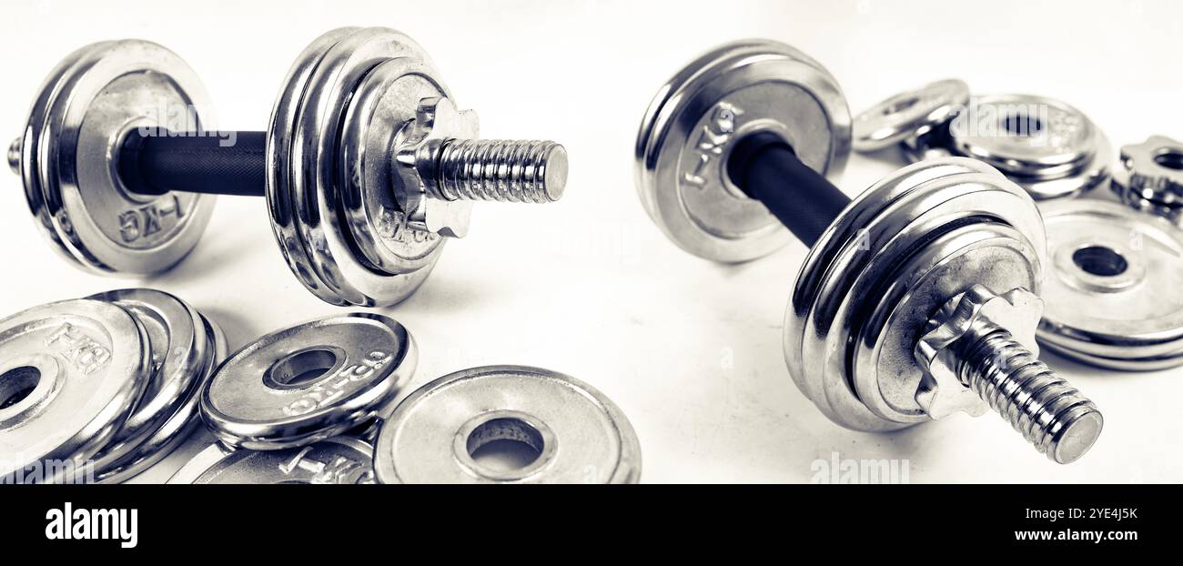 Fitnessgeräte und Sportkonzept. Doppelter Belichtungshintergrund. Kurzhanteln. Gesundes Leben und Fitness-Studio. Stockfoto