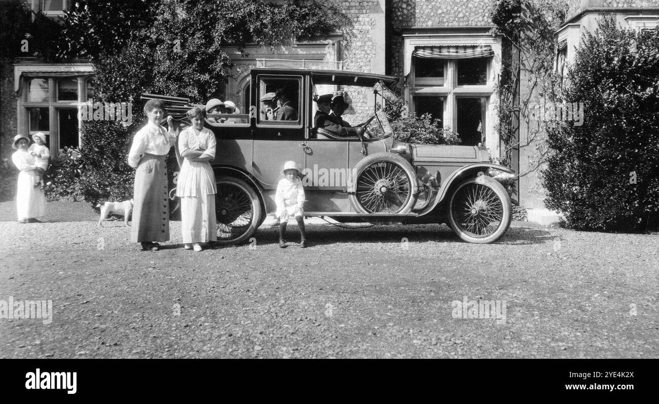 West Sussex, England. c.1913 – Mitglieder der Familie Henty posieren für ein Foto mit einem Landaulette-Oldtimer außerhalb von Ferring Grange in Ferring, einem Küstendorf in West Sussex. Das Anwesen war das Zuhause von Edwin Henty, J. P, D.L., F.S.A. (1844–1916), der als High Sheriff of Sussex gedient hatte. 1924 wurde das Haus in ein modisches Hotel umgewandelt, das von vielen Prominenten besucht wurde, darunter Edward, dem Prinzen von Wales (später bekannt als Duke of Windsor). Das Haus wurde im Oktober 1946 durch einen Brand zerstört. Stockfoto