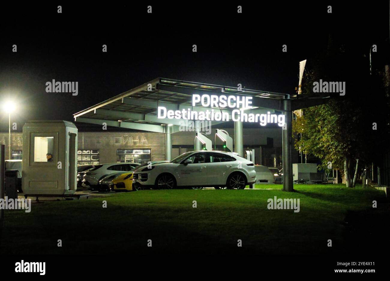 Almaty, Kasachstan - 18. Oktober 2024: Elektrische Porsche-Autos parken nachts an einer Ladestation. Händlerbetrieb Stockfoto