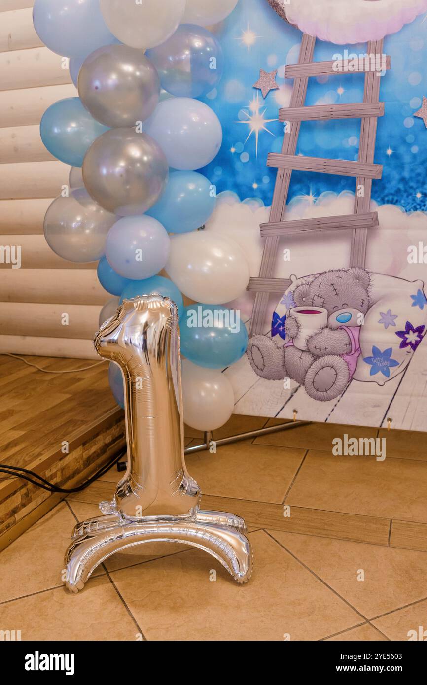 Silberfolie Ballon Nummer eins umgeben von blauen und weißen Ballons für den ersten Geburtstag. Stockfoto