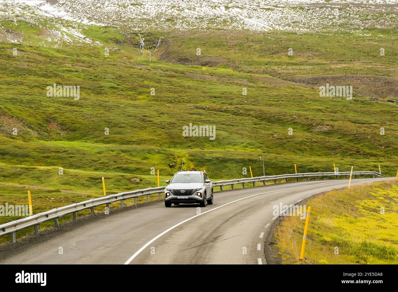 Akureyri, Island - 24. August 2024: Auto fährt auf einer der kurvenreichen Straßen über Berge in den abgelegenen Gebieten des Nordens Islands. Stockfoto