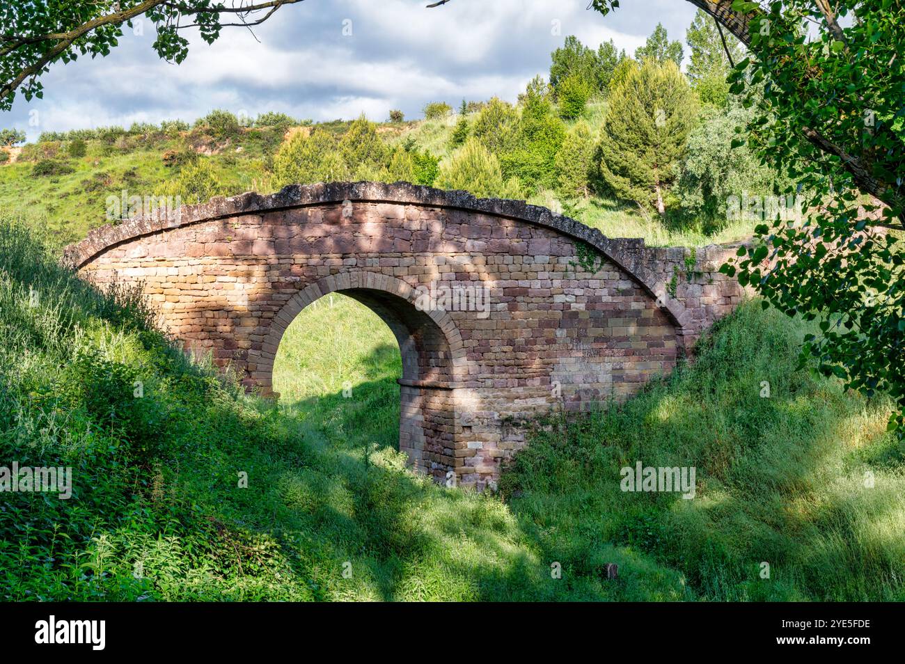Die alte römische Steinbrücke direkt vor dem Dorf Cirauqui in Spanien Stockfoto