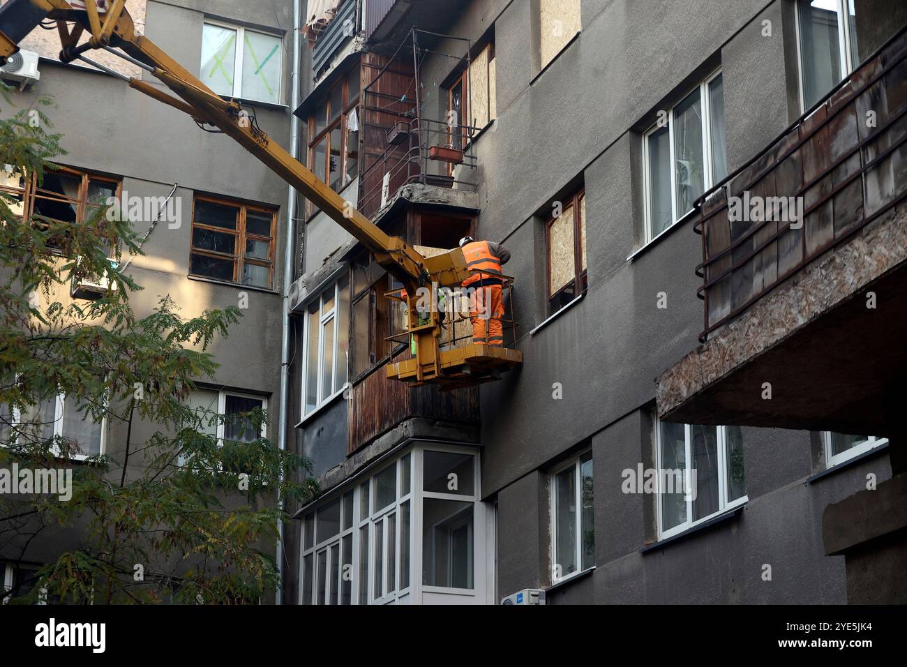 CHARKIW, UKRAINE - 28. OKTOBER 2024 - Ein Mann auf einer Hebebühne beseitigt die Folgen der russischen Bombardierung des Derschprom-Gebäudes in Charkiw, Nordostukraine Stockfoto