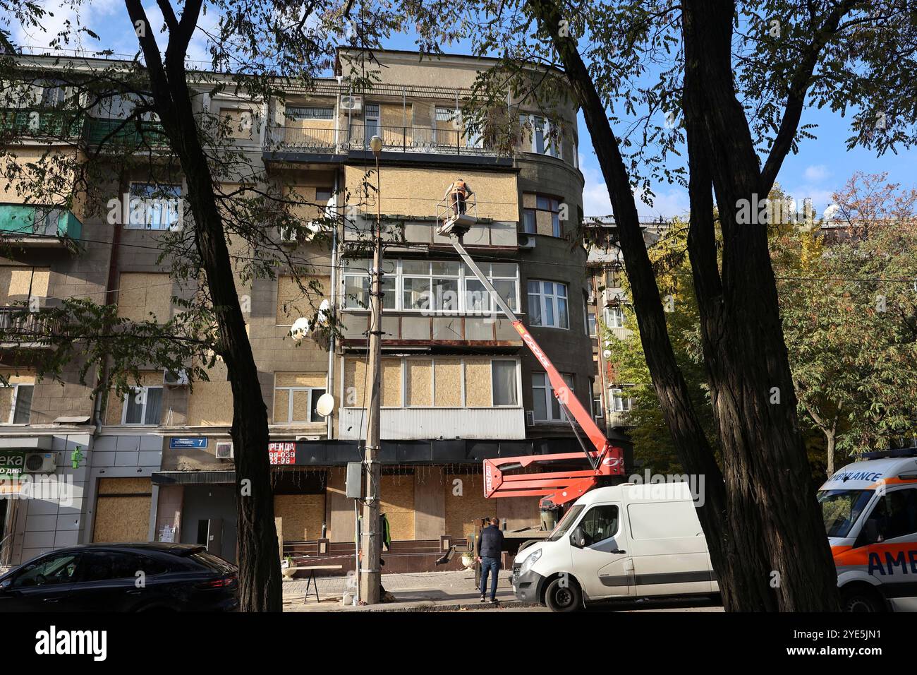 CHARKIW, UKRAINE - 28. OKTOBER 2024 - Ein Mann auf einer Hebebühne beseitigt die Folgen der russischen Bombardierung des Derschprom-Gebäudes in Charkiw, Nordostukraine Stockfoto
