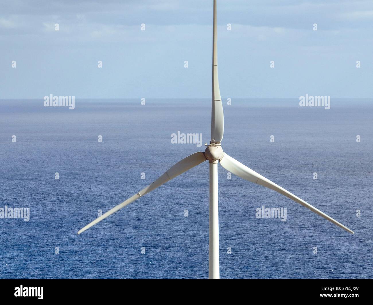 Windkraftwerk mit Windturbinen mit einem Ozean im Hintergrund, Stockfoto