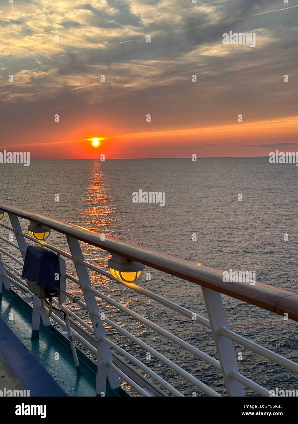 Sonnenuntergang an einem klaren Tag auf einem Kreuzfahrtschiff über dem Meer. - Smartphone-aufgenommenes Stockfoto