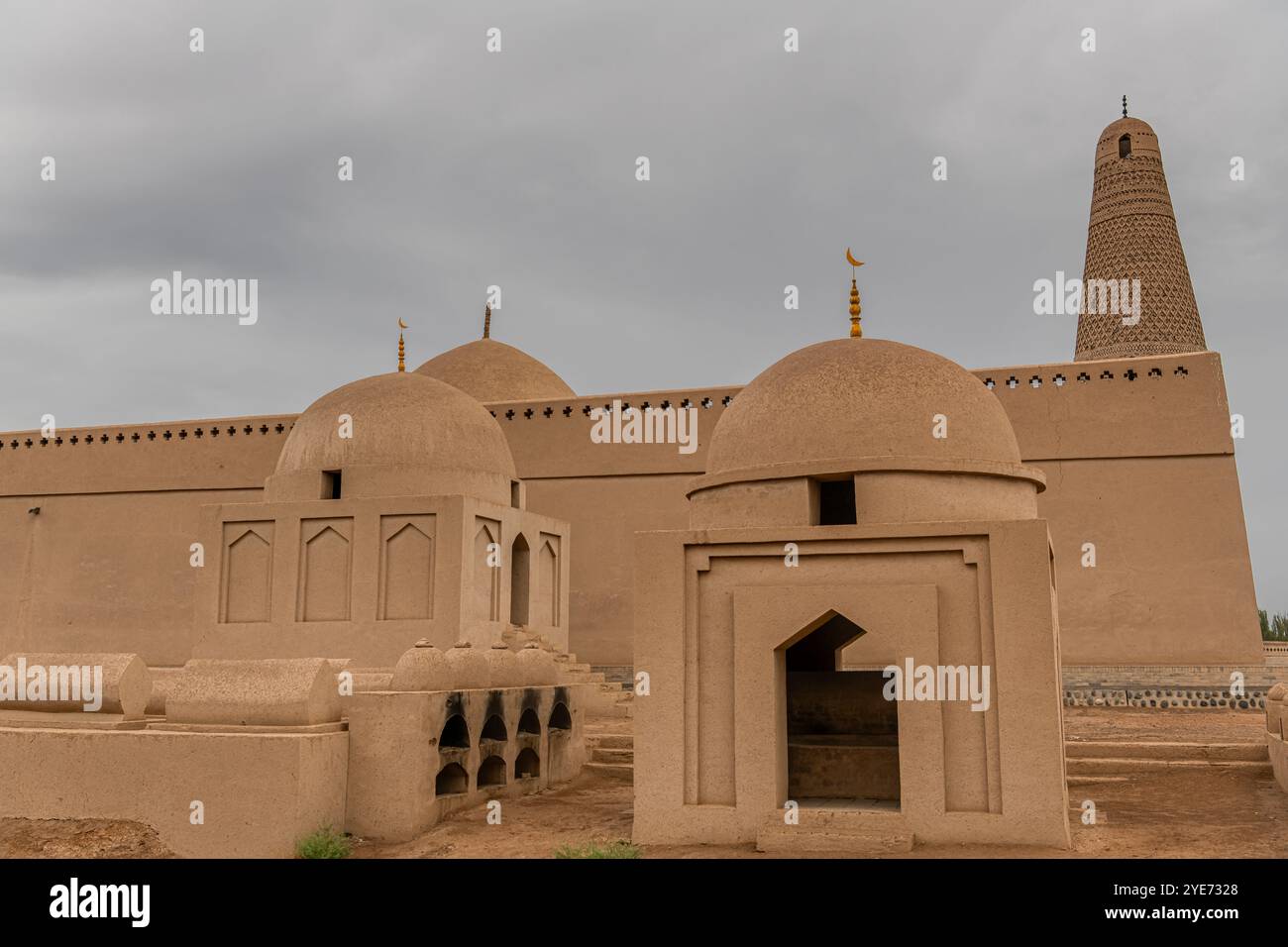 Das Emin-Minarett und die uigurische Moschee, sichtbar hinter den Gräbern in Turpan in der Provinz Xinjiang in Westchina Stockfoto