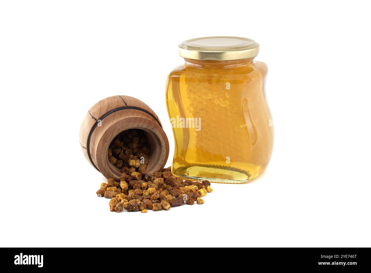 Natürliches Bienenbrot, das aus einem Holzfass verschüttet wird, neben einem Glas, das mit goldenem Honig gefüllt ist, isoliert auf weißem Hintergrund Stockfoto