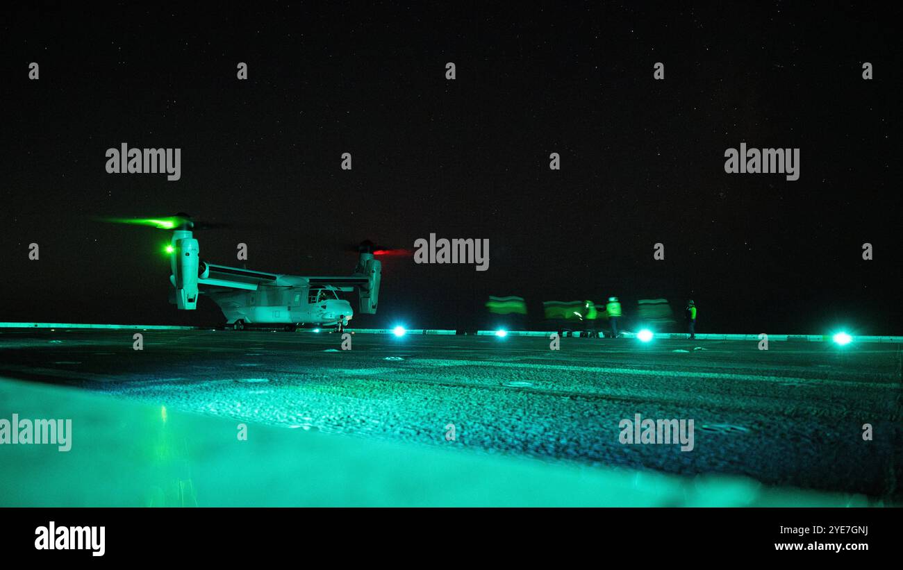 Seefahrer der US Navy, die dem Amphibien-Transportschiff USS Somerset (LPD 25) der San Antonio-Klasse zugeteilt wurden, durchquerten das Flugdeck, um eine U.S. Mari zu sichern Stockfoto