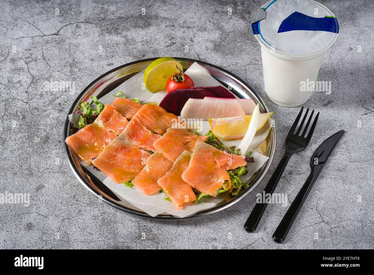 Räucherlachs mit Gemüse darunter auf einem Steintisch Stockfoto