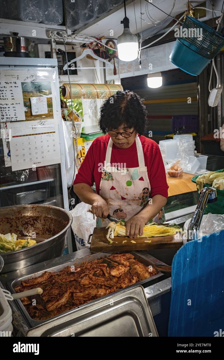 Koreanische Frau, die traditionelles koreanisches Gericht Kimchi auf dem Markt in Seoul, Südkorea, zubereitet Stockfoto