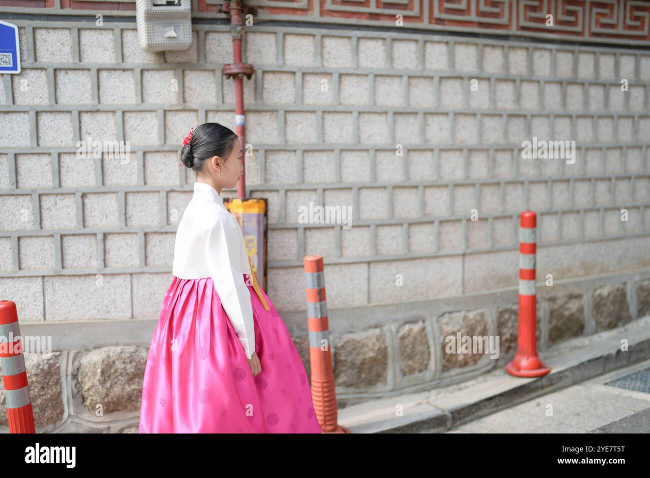 Ein 9-jähriges koreanisches Mädchen mit Hanbok spaziert durch die historischen Straßen von Gyedong-gil, Jongno District, Seoul, Korea. Stockfoto