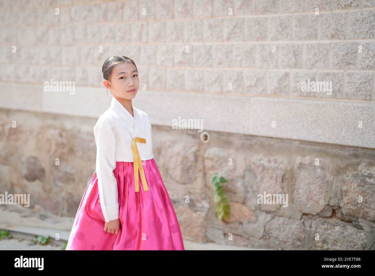 Ein 9-jähriges koreanisches Mädchen mit Hanbok spaziert durch die historischen Straßen von Gyedong-gil, Jongno District, Seoul, Korea. Stockfoto