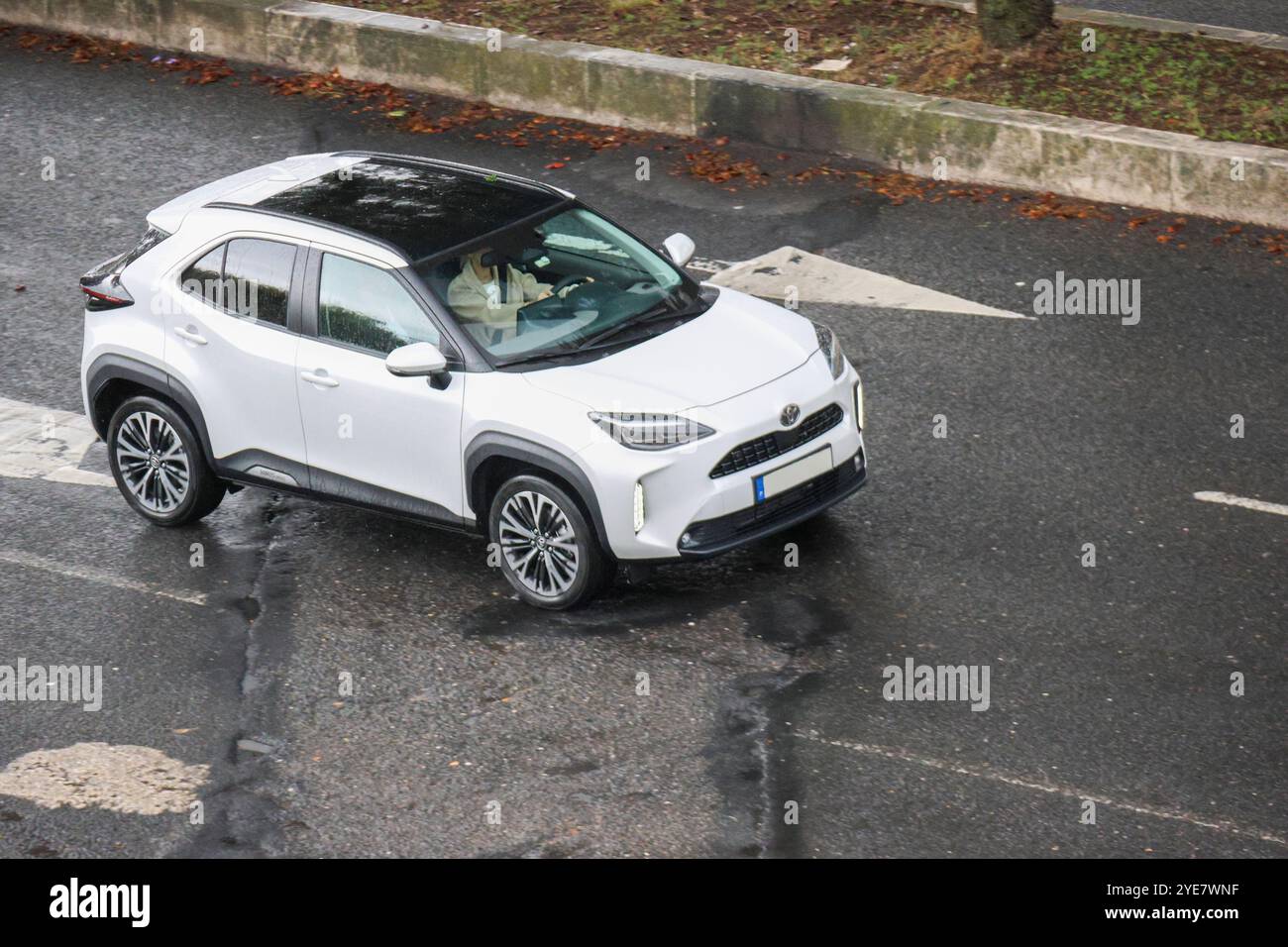 Das weiße toyota yaris Cross fährt auf der Straße mit verschwommenem Hintergrund Stockfoto