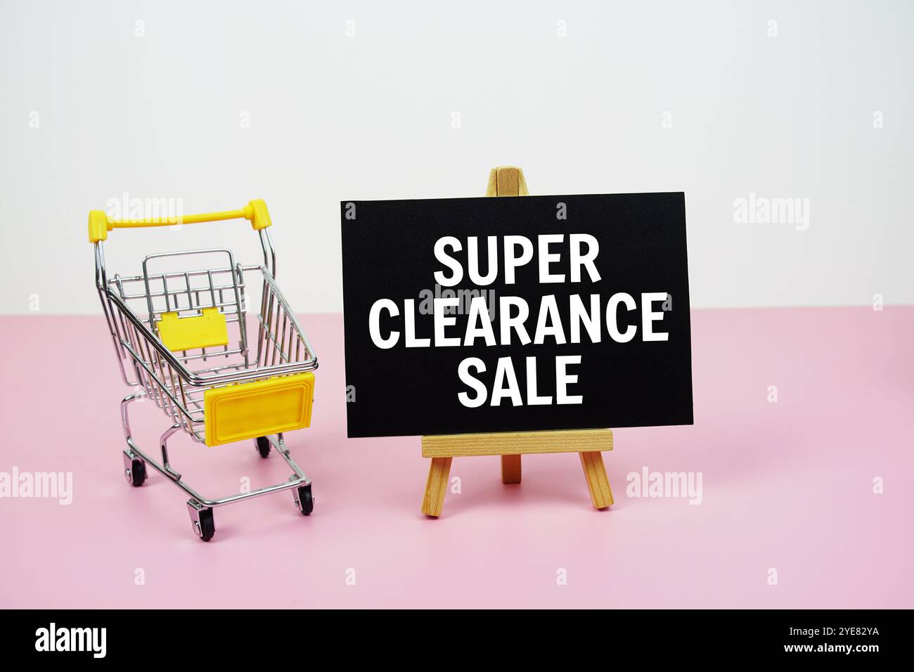 Super Clearance Sale Textnachricht und Einkaufswagen auf rosafarbenem Hintergrund Stockfoto