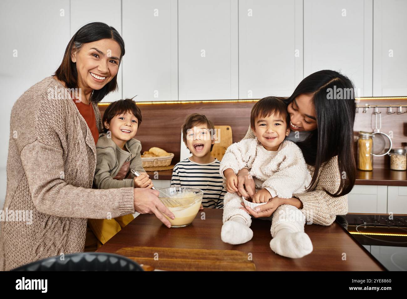 Eine fröhliche Familie genießt es, in einer modernen Küche zu backen und festliche Leckereien für die Winterferien zu kreieren. Stockfoto