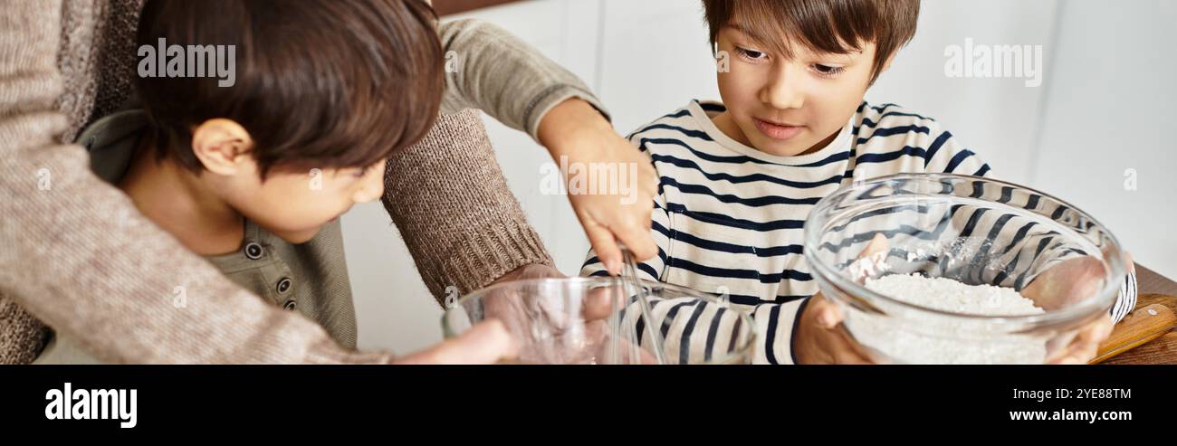 Eine warme Küchenatmosphäre voller Lachen, während eine Großmutter ihren Enkeln beim gemeinsamen Backen von Urlaubsspeisen hilft. Stockfoto